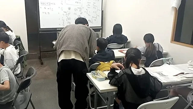 みやうち塾の講師が、生徒の横で学習を見ている授業の様子